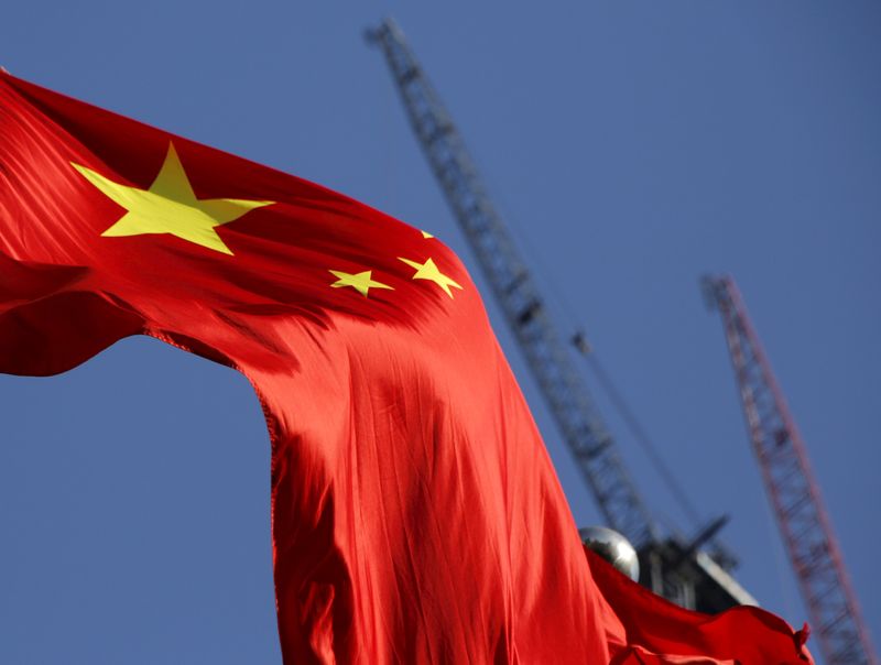 © Reuters. FILE PHOTO: China's national flag is seen in front of cranes on a construction site at a commercial district in Beijing, China, January 26, 2016. REUTERS/Kim Kyung-Hoon
