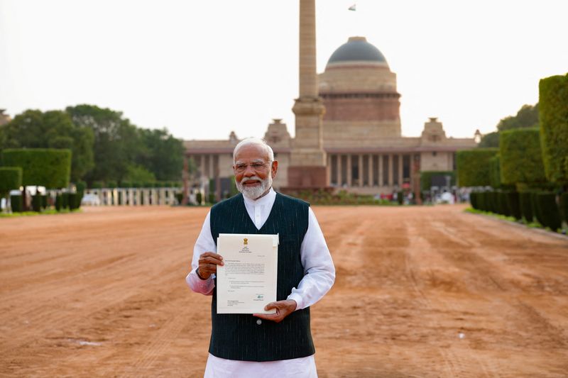 © Reuters. India's Prime Minister Narendra Modi shows media a letter that he received from India's President Droupadi Murmu inviting him to form a new government after meeting her at the Presidential Palace in New Delhi, India, June 7, 2024. REUTERS/Adnan Abidi