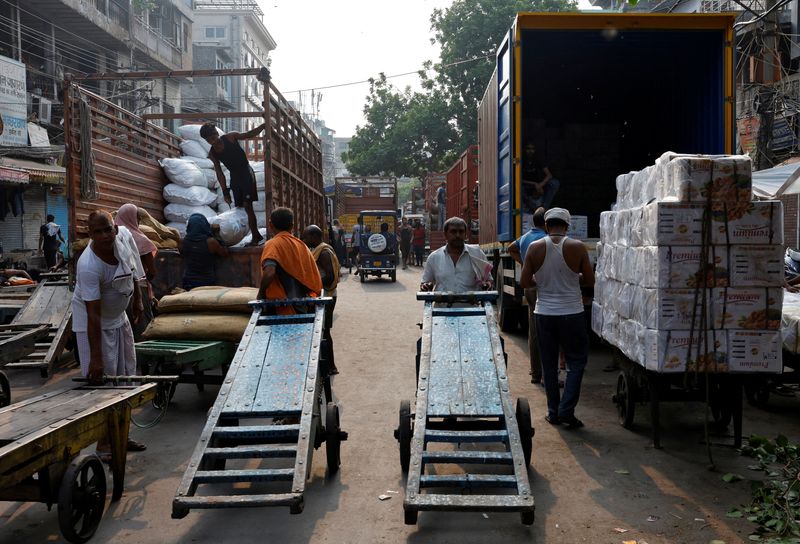 © Reuters. FILE PHOTO: Labourers unload spices and dry fruits from supply trucks at a wholesale market in the old quarters of Delhi, India, July 22, 2024. REUTERS/Priyanshu Singh/File photo