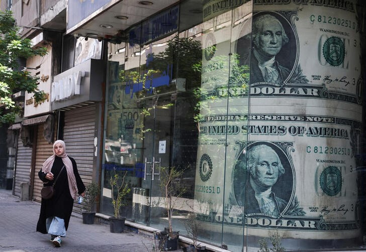 © Reuters. An Egyptian woman walks past a currency exchange point, displaying images of the U.S. dollar, in Cairo, Egypt May 9, 2024. REUTERS/Amr Abdallah Dalsh/file photo