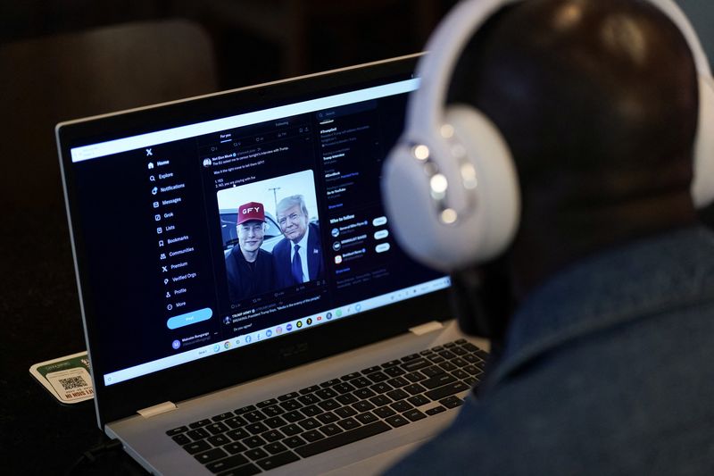 © Reuters. A person tries to watch on a laptop billionaire entrepreneur Elon Musk's interview with Republican presidential candidate and former U.S. President Donald Trump on the X social media network, in New York City, U.S. August 12, 2024.  REUTERS/Adam Gray