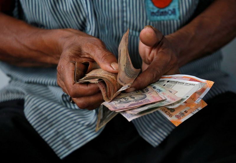 © Reuters. An attendant at a fuel station arranges Indian rupee notes in Kolkata, India, August 16, 2018. REUTERS/Rupak De Chowdhuri/File Photo