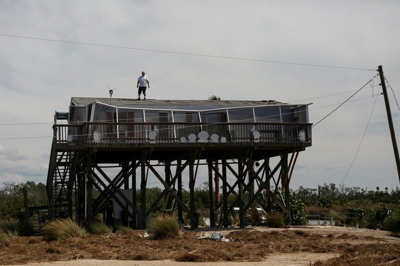 © Reuters. Thomas Mattox, 67, repairs holes in his roof, Spring Warrior Fish Camp, Florida, September 28, 2024. REUTERS/Octavio Jones