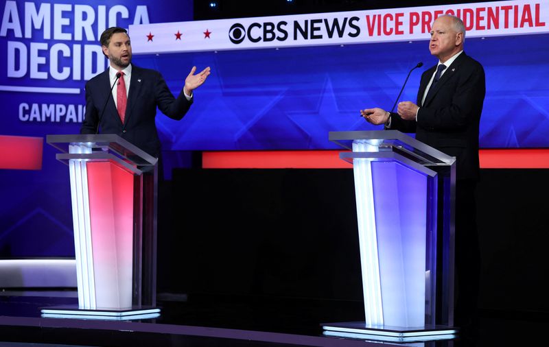 © Reuters. Republican vice presidential nominee U.S. Senator JD Vance (R-OH) and Democratic vice presidential nominee Minnesota Governor Tim Walz gesture as they speak during a debate hosted by CBS in New York, U.S., October 1, 2024. REUTERS/Mike Segar