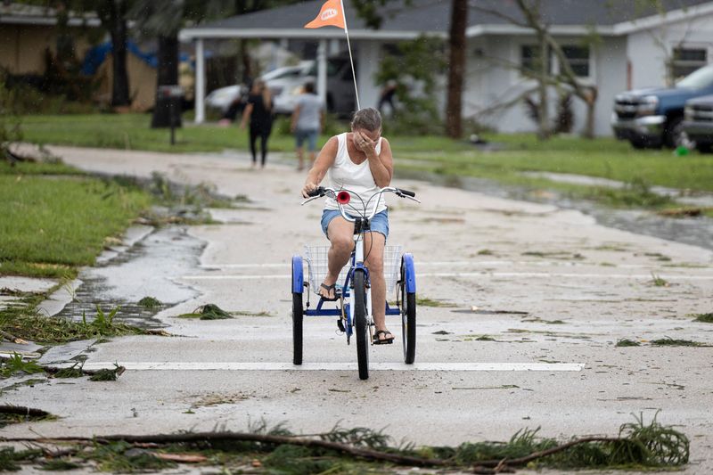 © Reuters. A woman cries after seeing the damages caused by a passing tornado as Hurricane Milton approaches Fort Myers, Florida, U.S. October 9, 2024. REUTERS/Ricardo Arduengo