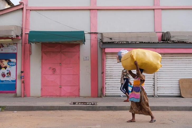 © Reuters. People walk in front of closed shops as traders lock up their stores in protest of Ghana's worsening economic conditions in Accra, Ghana October 19, 2022. REUTERS/Francis Kokoroko/File Photo