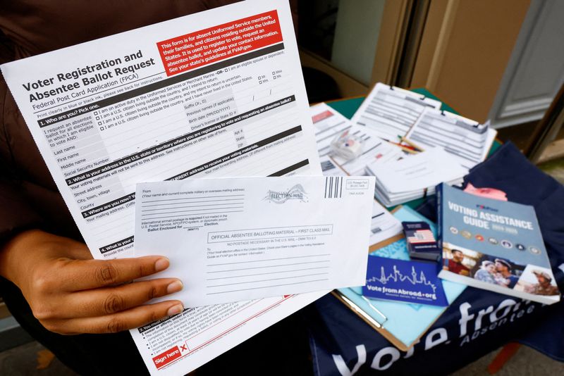 © Reuters. FILE PHOTO: A U.S. citizen abroad voter holds a voter registration and absentee ballot request form and an envelope which will contain an official absentee balloting material at a stand set up outside a cafe by Democrats Abroad volunteers to help Americans living in Paris to navigate the bureaucracies of state and local election laws, in Paris, France, October 21, 2024. REUTERS/Stephanie Lecocq/File Photo