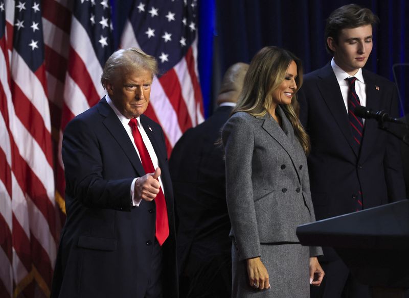 © Reuters. Republican presidential nominee and former U.S. President Donald Trump gestures as he is accompanied by Melania Trump and Barron Trump following early results from the 2024 U.S. presidential election in Palm Beach County Convention Center, in West Palm Beach, Florida, U.S., November 6, 2024. REUTERS/Carlos Barria