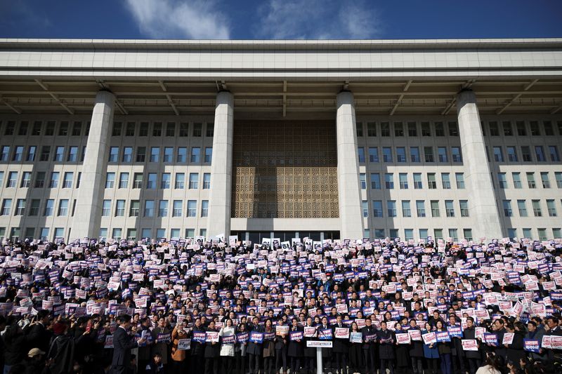 © Reuters. Protesters hold up signs as people and lawmakers attend a rally to condemn South Korean President’s surprise declarations of the martial law last night and to call for his resignation, at the national assembly in Seoul, South Korea, December 4, 2024. REUTERS/Kim Hong-Ji