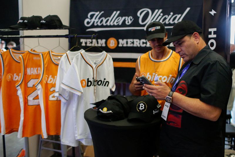 © Reuters. FILE PHOTO: A man pays for a jersey with Bitcoin during the launch of Adopting Bitcoin 2024 – The high signal Bitcoin conference for builders, in Nuevo Cuscatlan, El Salvador, November 15, 2024. REUTERS/Jose Cabezas/File Photo